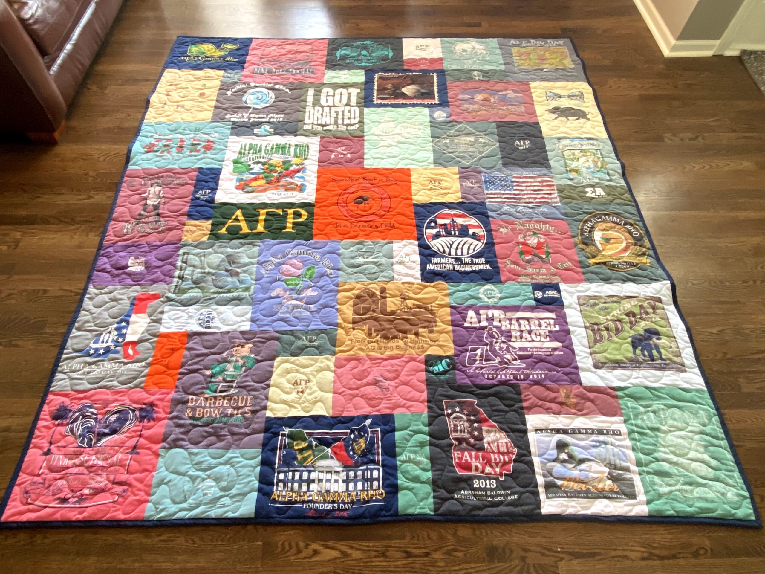 A quilt made of all the t-shirts that are on top of it.