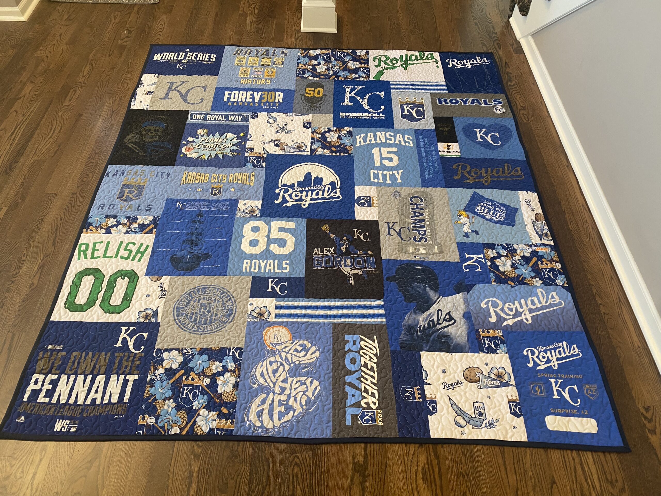 A quilt made of baseball shirts on top of a table.